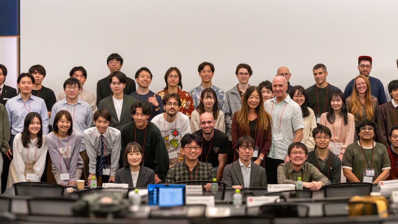 Participants from OIST and Keio University pose together for a group photo at the OIST-Keio Showcase Talk Series Vol. 10, standing at the front of a seminar room.
