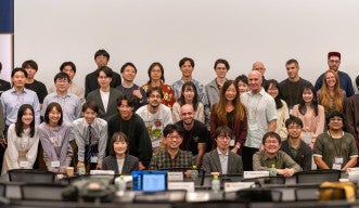 Participants from OIST and Keio University pose together for a group photo at the OIST-Keio Showcase Talk Series Vol. 10, standing at the front of a seminar room.
