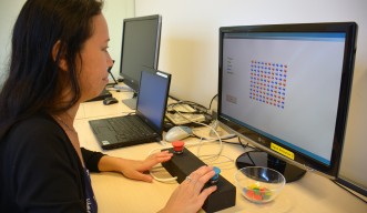 Dr Emi Furukawa, from the Human Developmental Neurobiology Unit, demonstrates the game used during the research.