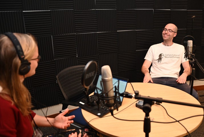 2 person sitting around a table and a microphone