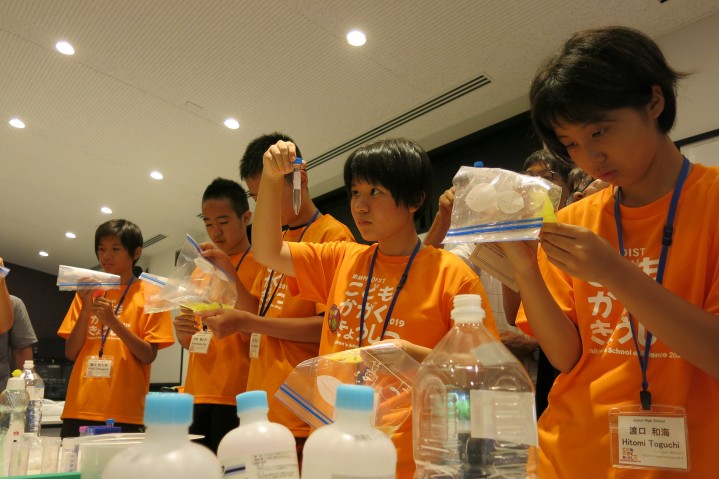 Junior hight school students doing an experiment with a scientist