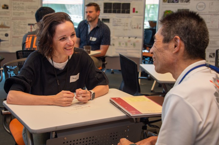 Female professor and male professor smiling and talking