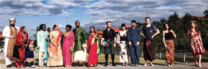 Members of various clubs/extracurriculars stand together in diverse outfits/clothes.