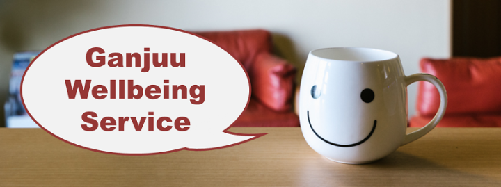 A mug with smiley face and a speech bubble stating, "Ganjuu Wellbeing Service"