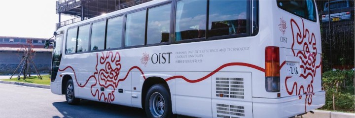 OIST Shuttle Bus parked in front of a multistory garage