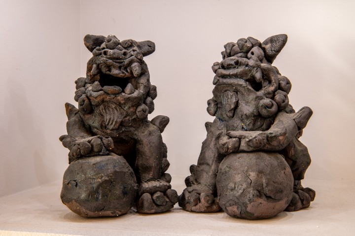 Two shisa, Okinawan traditional statues of animals similar to dogs. The right one has its mouth closed while the left has its mouth open.