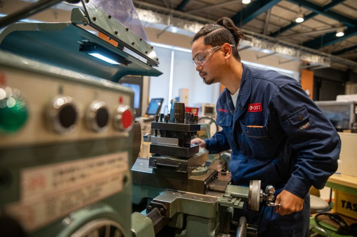 Personnel operating a lathe within the Engineering Section of OIST