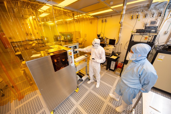 two cleanroom users are operating a maskless lithography system, fully gowned