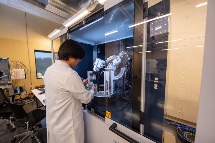 Staff loading samples into an autoloader for a Bruker D8 powder diffraction system.