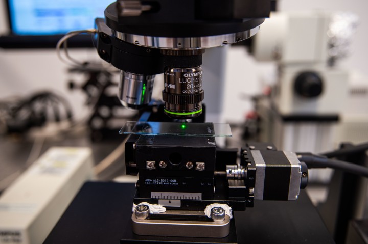 close-up view on a microscope with a laser spot in the focus on a glass slide