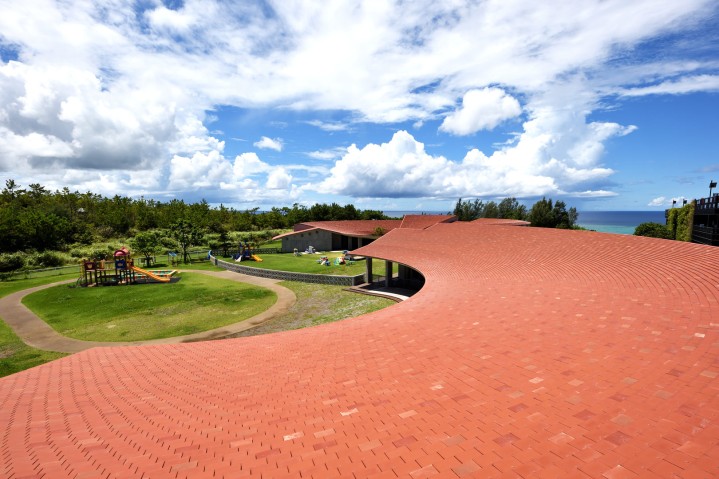 Red-roofed buildign and green field