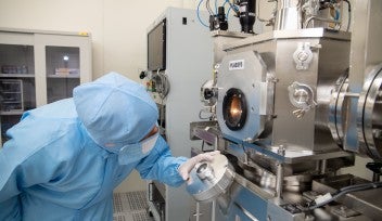 Staff doing a deposition run on a sample in a chamber within a cleanroom