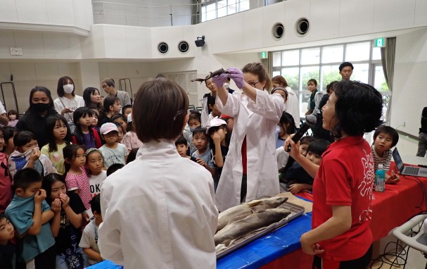 Fabienne showing students shark specimens during outreach event.