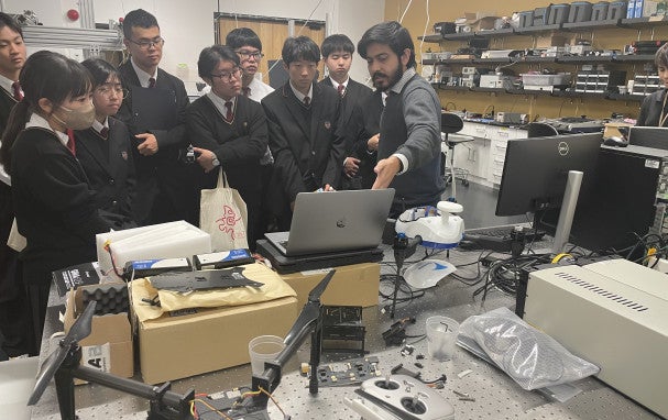 Soumen showing visiting students something on a PC.