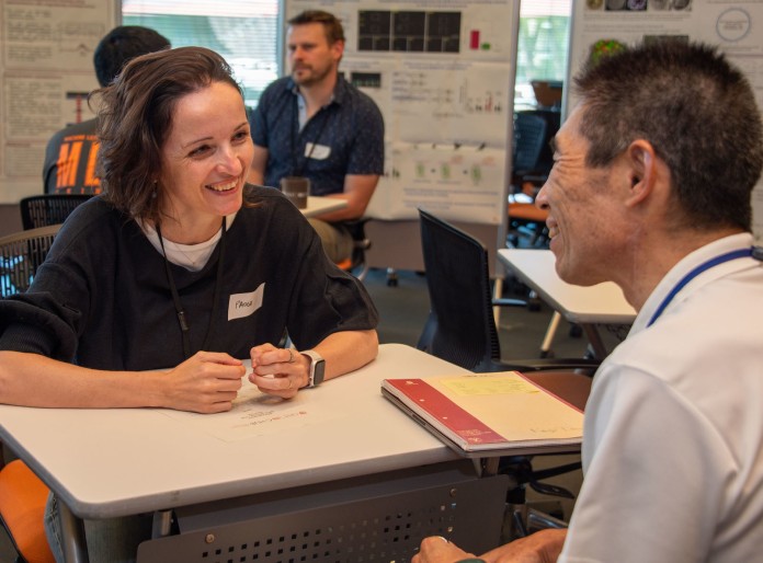 Female professor and male professor smiling and talking